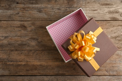 Open empty gift box on wooden table, top view. Space for text