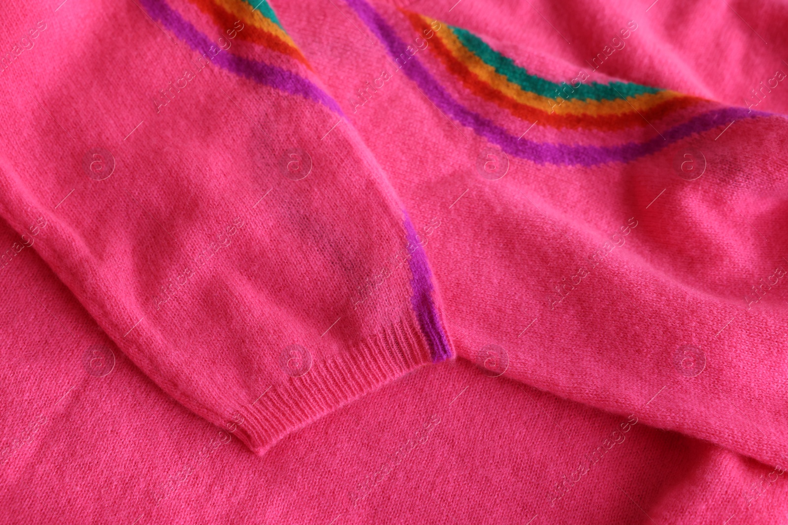 Photo of Beautiful pink sweater as background, closeup view