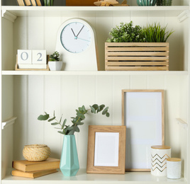 White shelving unit with photo frames and different decorative elements