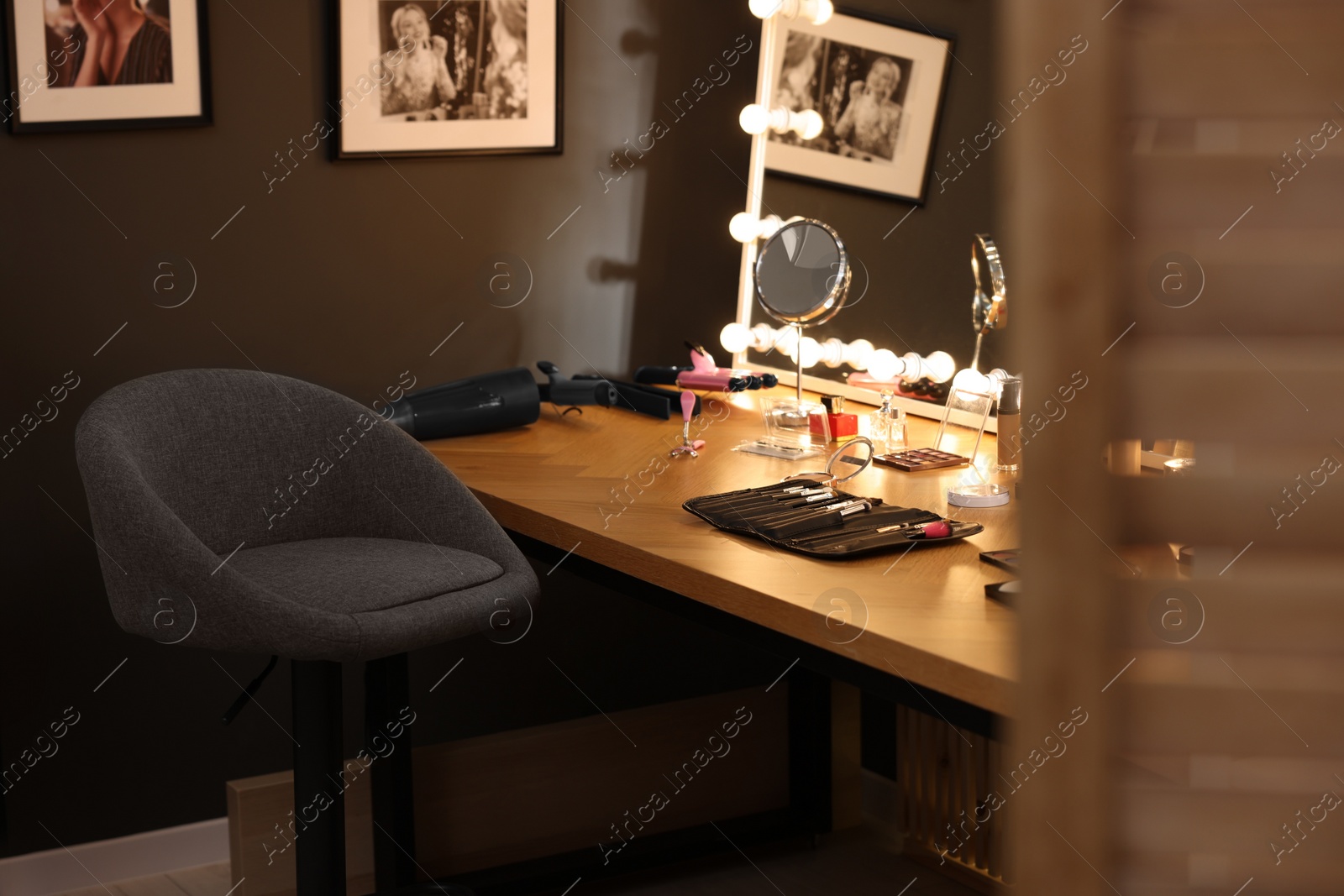 Photo of Makeup room. Stylish mirror on dressing table with different beauty products