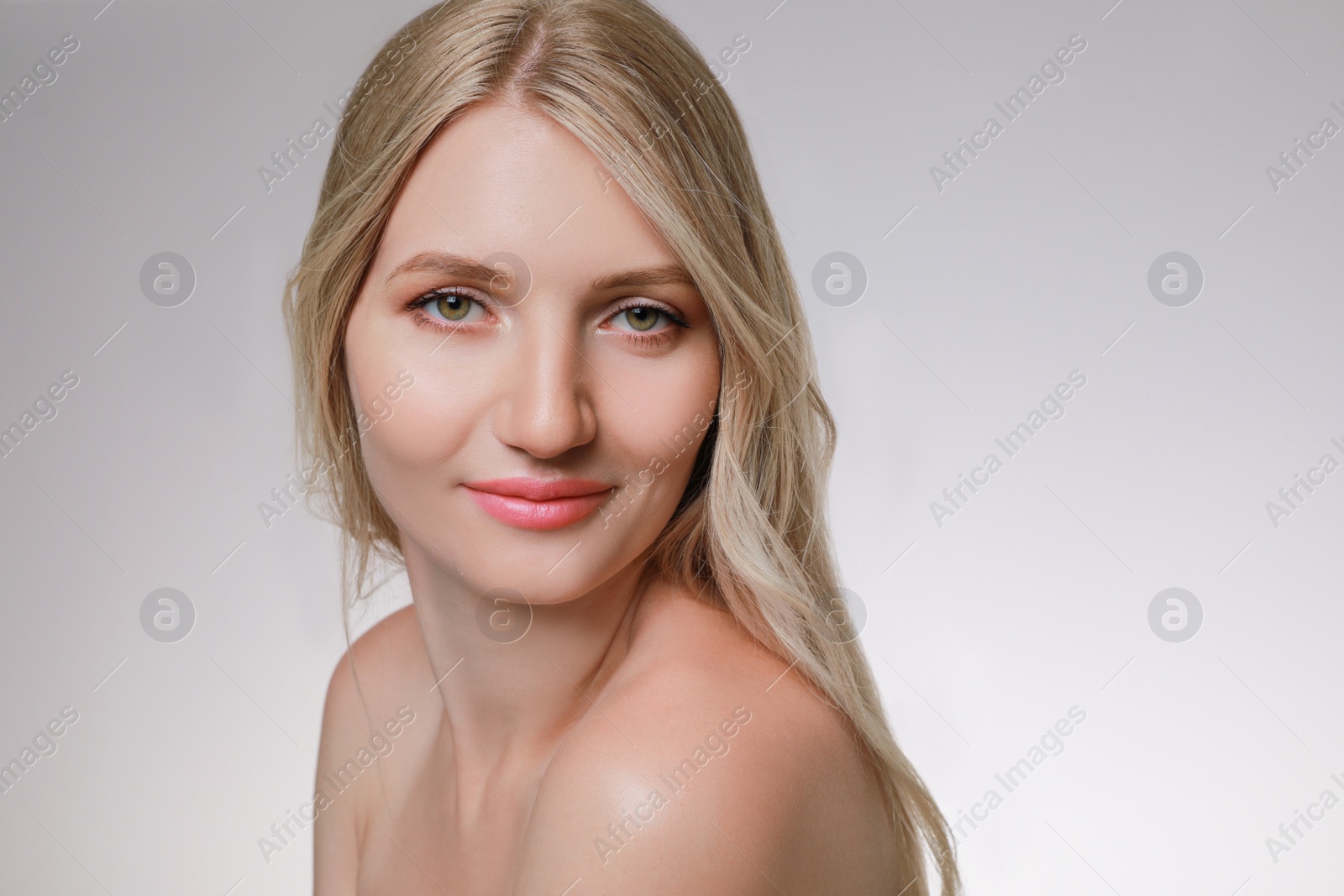 Photo of Portrait of young woman with beautiful face on beige background
