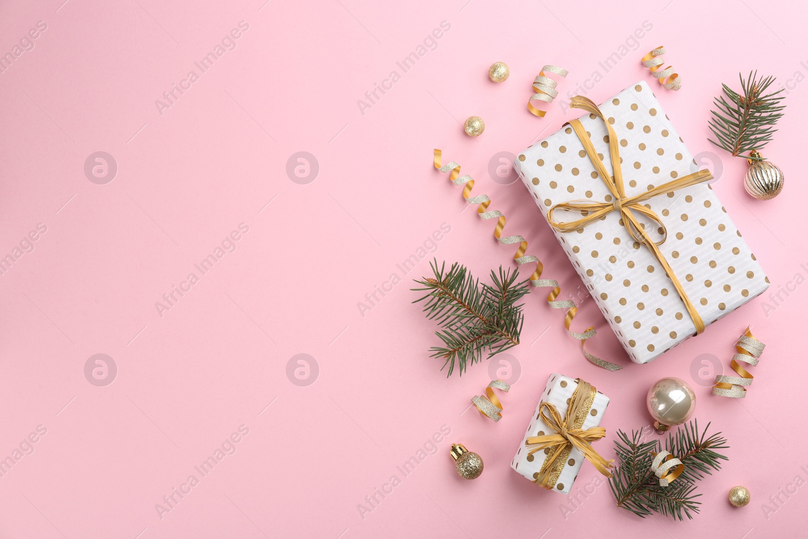 Photo of Flat lay composition with serpentine streamers and Christmas decor on pink background. Space for text