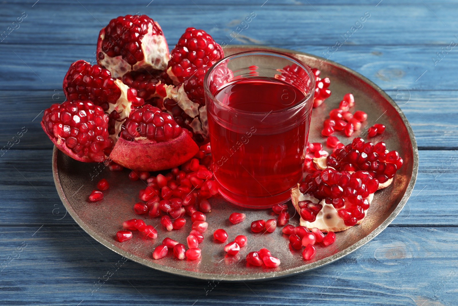 Photo of Tray with glass of pomegranate juice and fresh fruits on wooden background