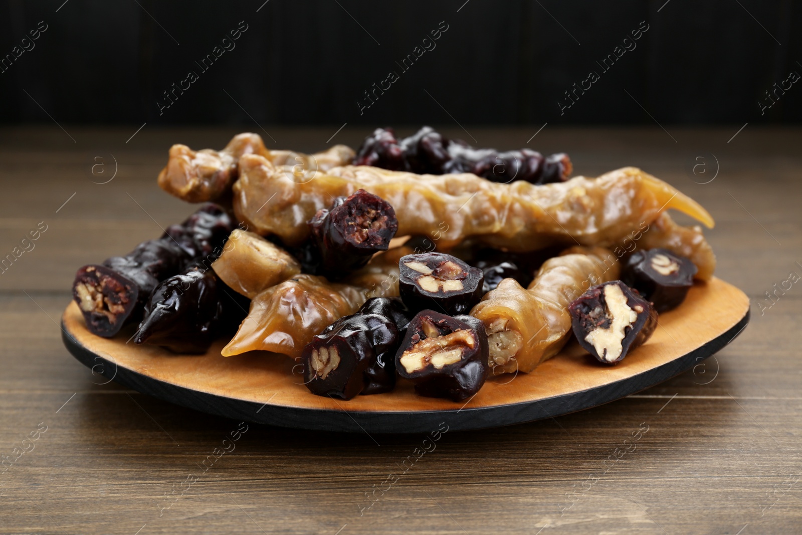 Photo of Many delicious sweet churchkhelas on wooden table