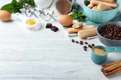 Photo of Composition with tiramisu ingredients on white wooden table, space for text