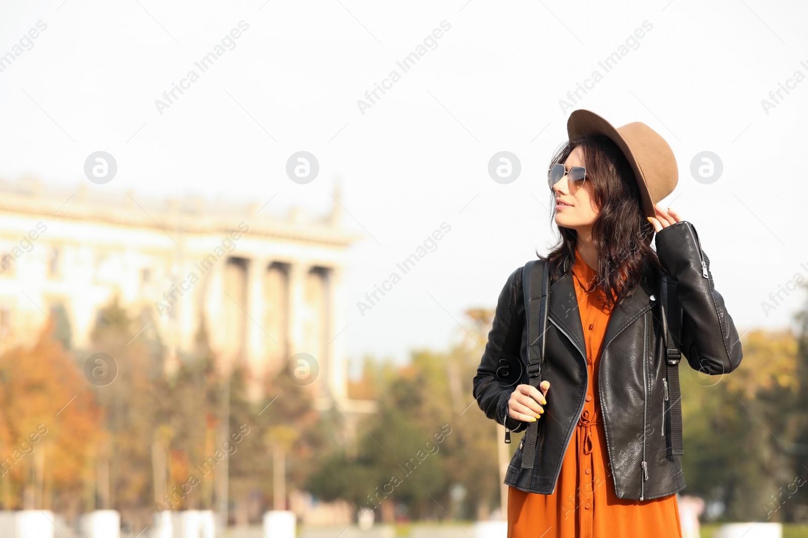 Photo of Traveler in hat with backpack on city street