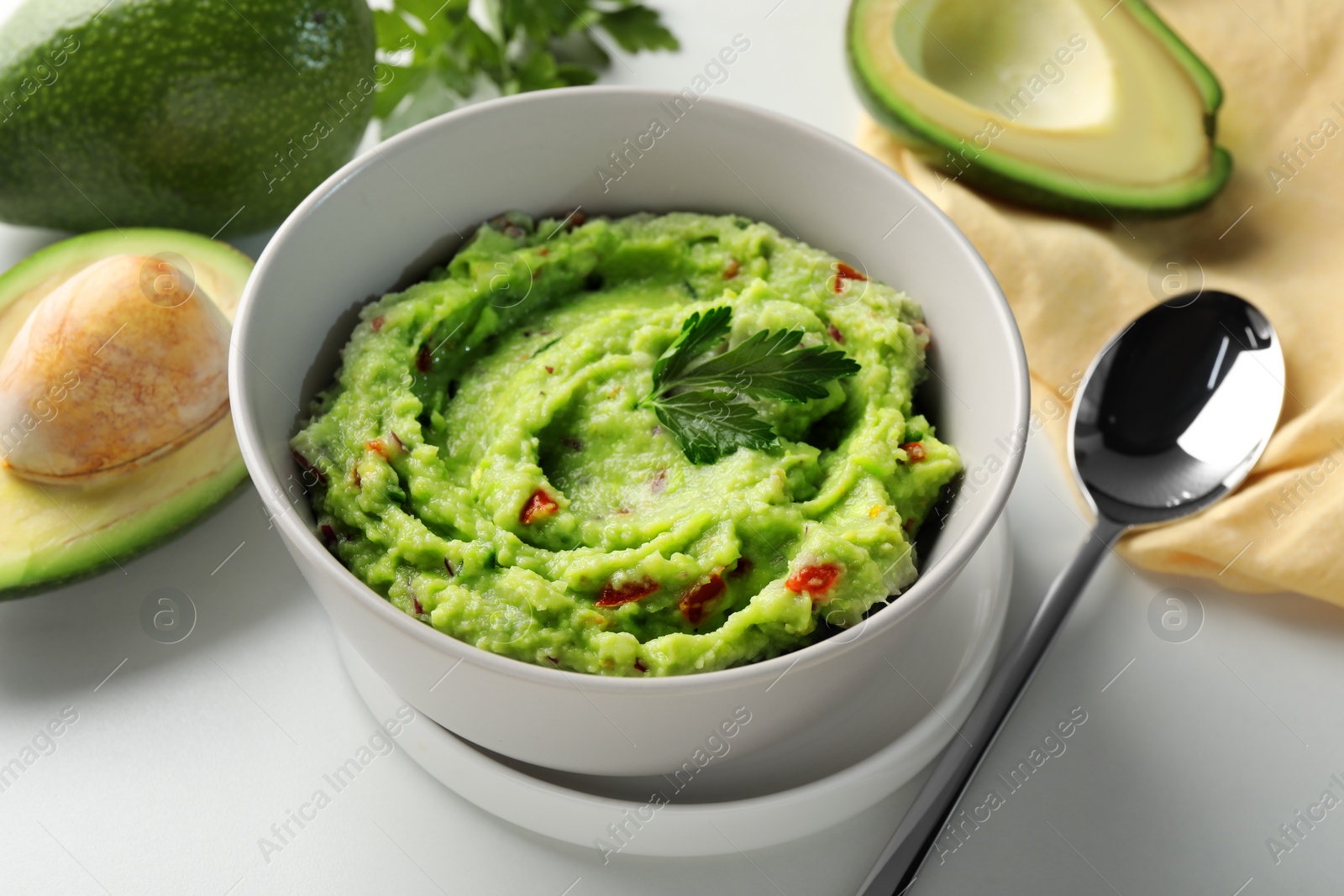 Photo of Delicious guacamole with avocado served on white table