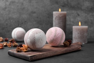 Photo of Bath bombs, candles and dry flowers on black table