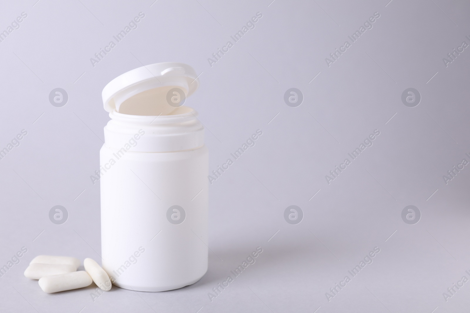 Photo of Jar with chewing gums on light grey background. Space for text