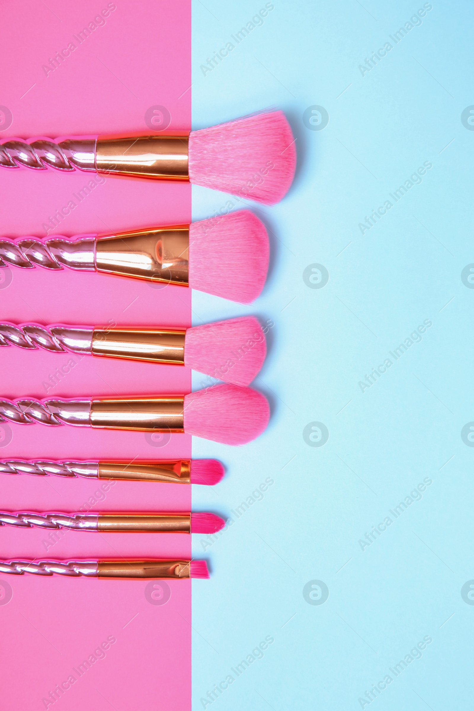 Photo of Flat lay composition with set of professional makeup brushes on color background. Space for text