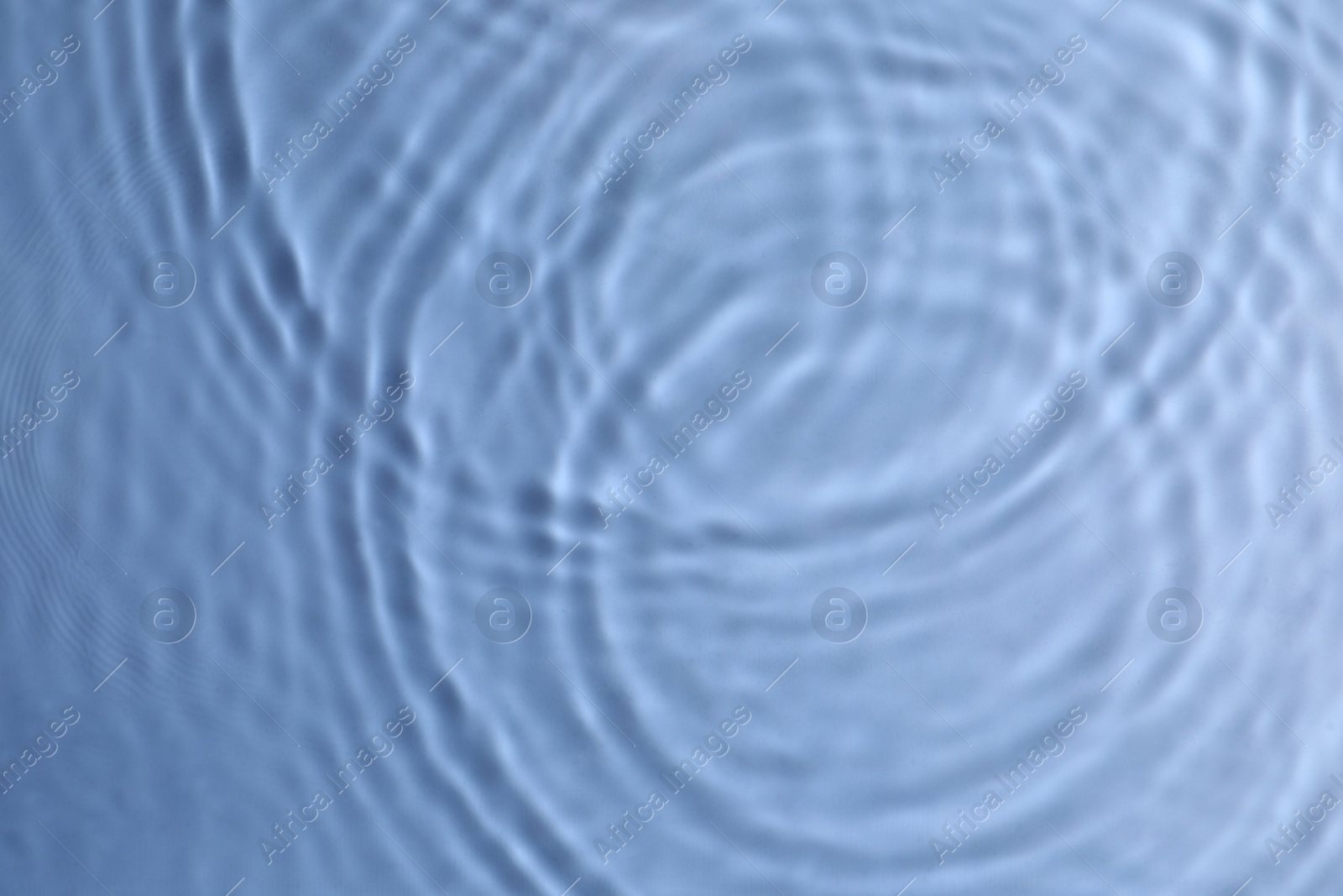 Photo of Closeup view of water with circles on blue background