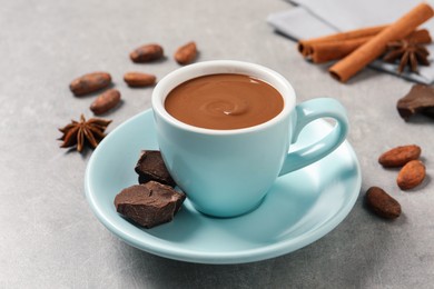 Photo of Yummy hot chocolate in cup on light grey table