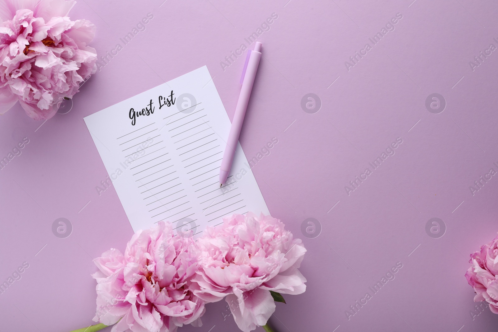 Photo of Guest list, pen and beautiful flowers on violet background, flat lay. Space for text