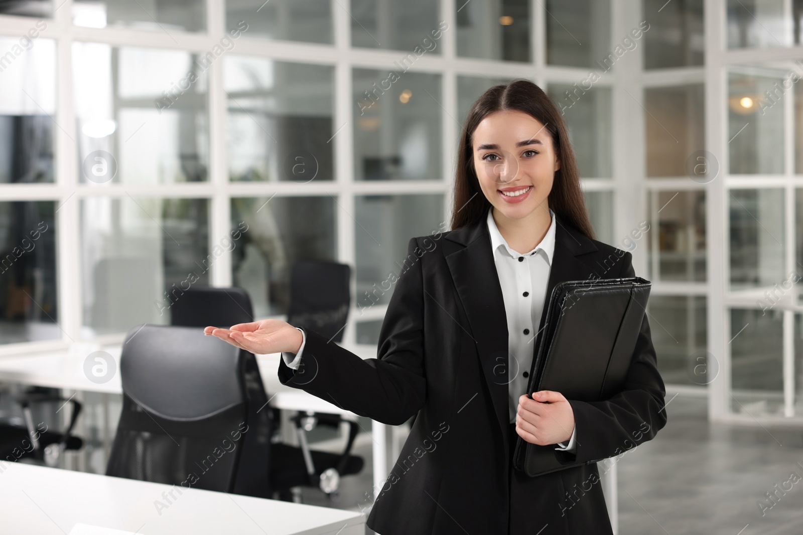 Photo of Happy real estate agent with leather portfolio in office