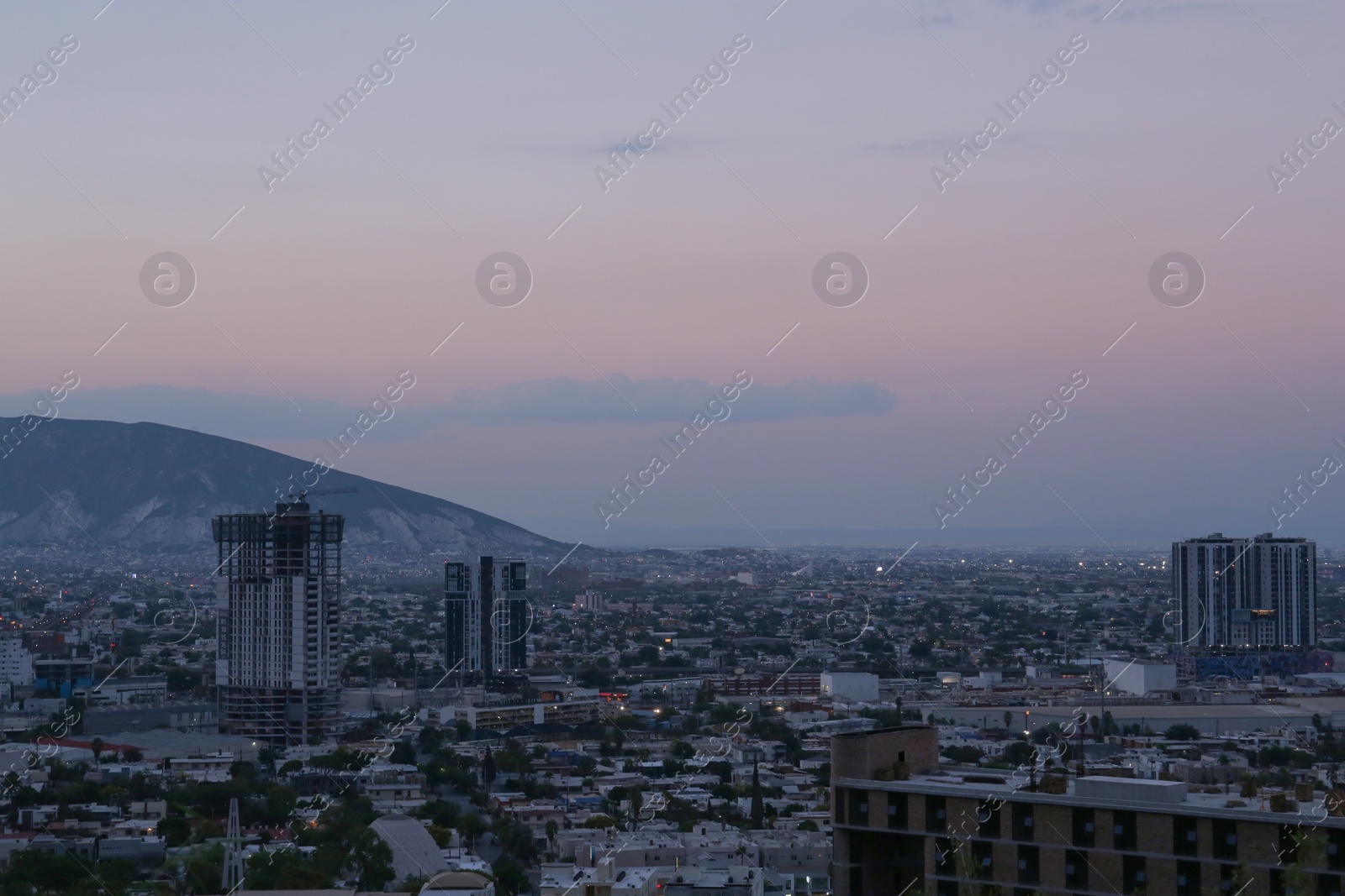 Photo of Picturesque view of sunset above big mountain and city