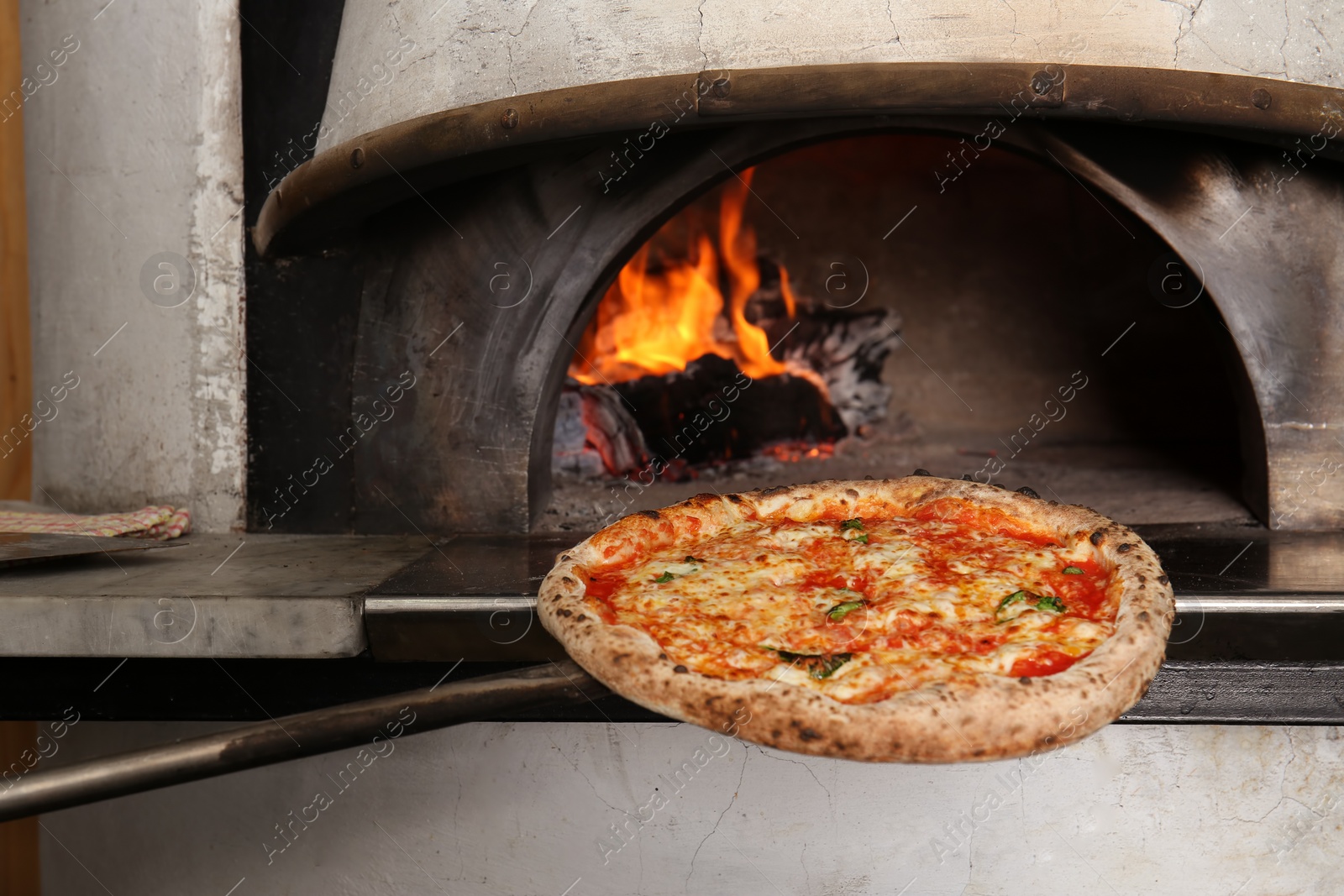 Photo of Putting tasty pizza into oven in  restaurant kitchen