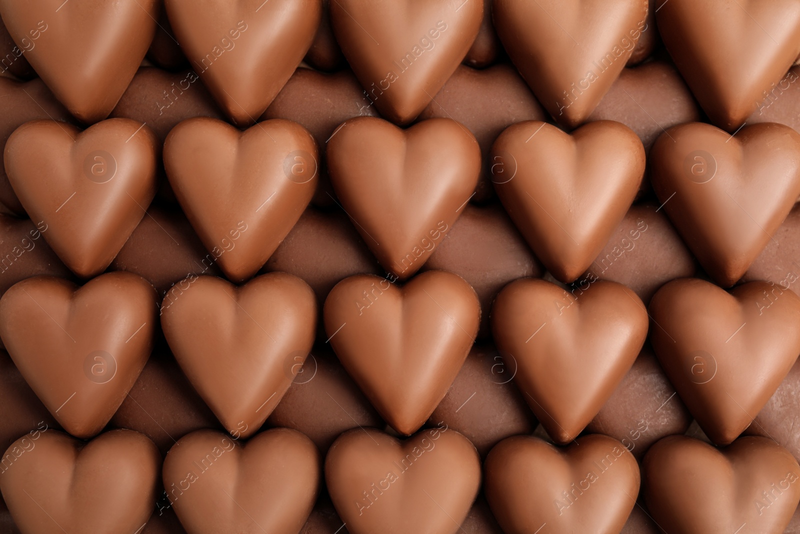 Photo of Tasty heart shaped chocolate candies as background, top view. Valentine's day celebration