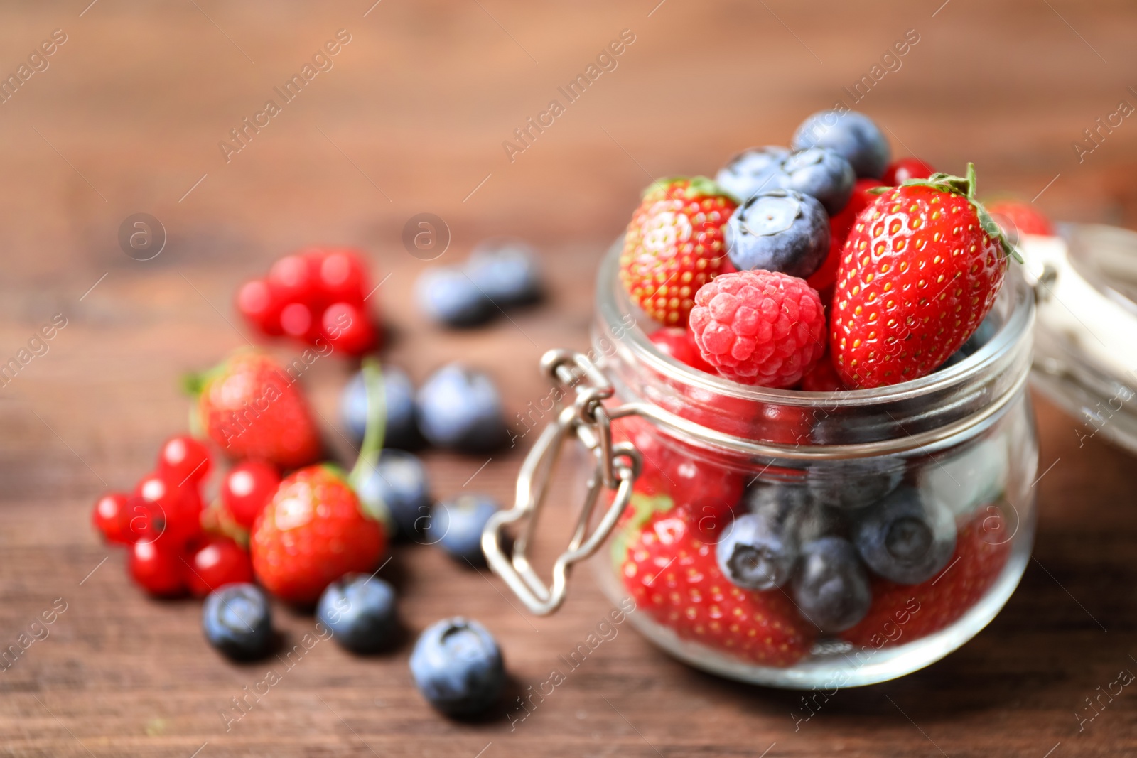 Photo of Mix of ripe berries on wooden table, closeup