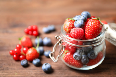 Mix of ripe berries on wooden table, closeup