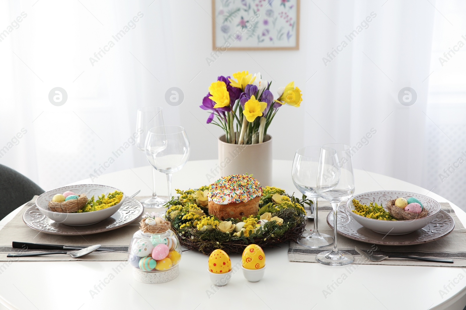 Photo of Festive Easter table setting with beautiful flowers and eggs indoors