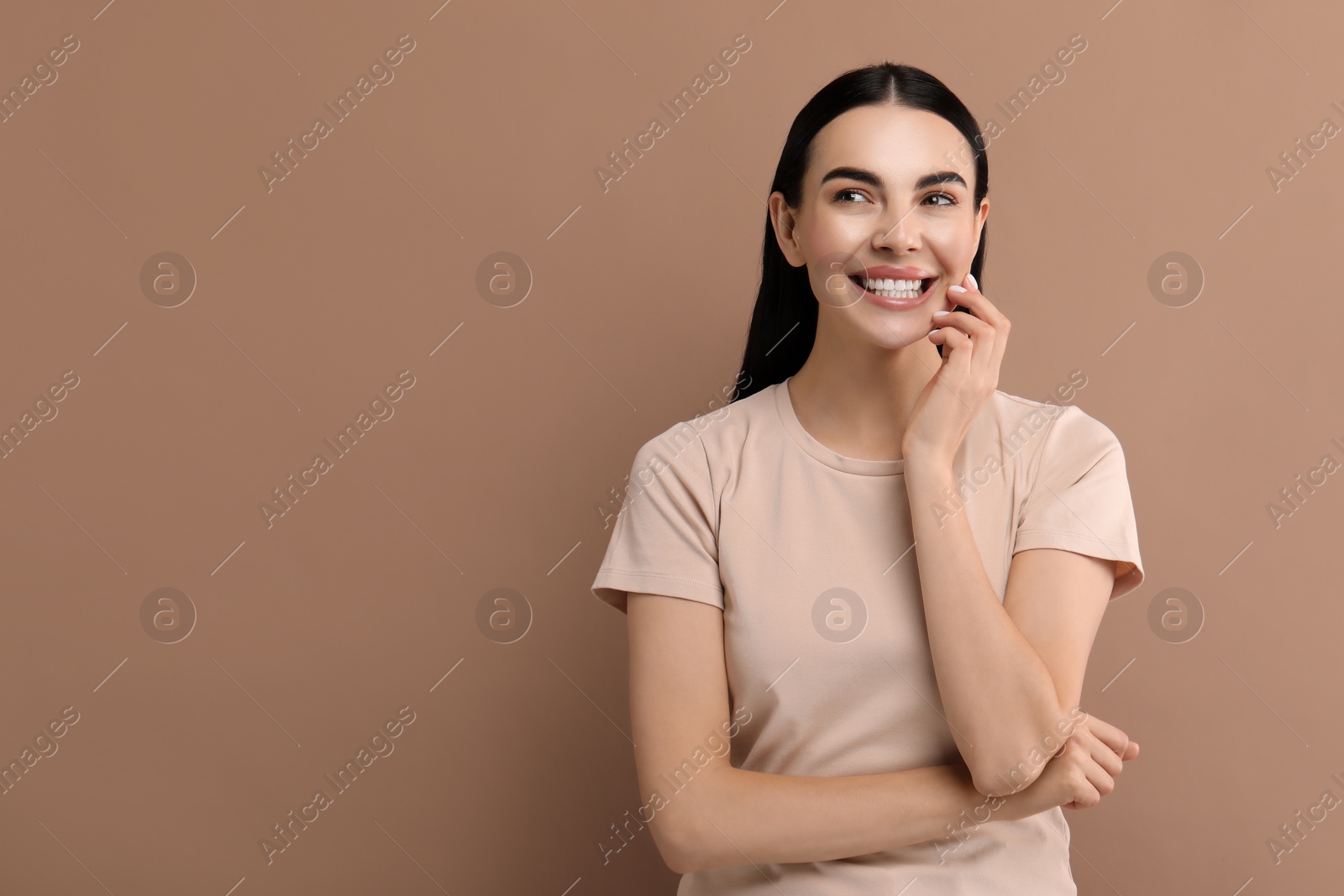 Photo of Beautiful woman with clean teeth smiling on beige background, space for text