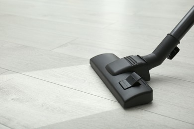 Image of Vacuuming dirty white wooden floor. Clean area after using device, closeup