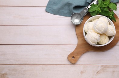 Photo of Bowl of ice cream and mint leaves on light wooden table, flat lay. Space for text