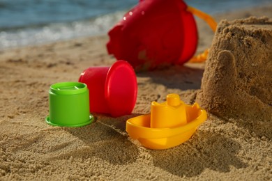 Set of plastic beach toys on sand near sea. Outdoor play