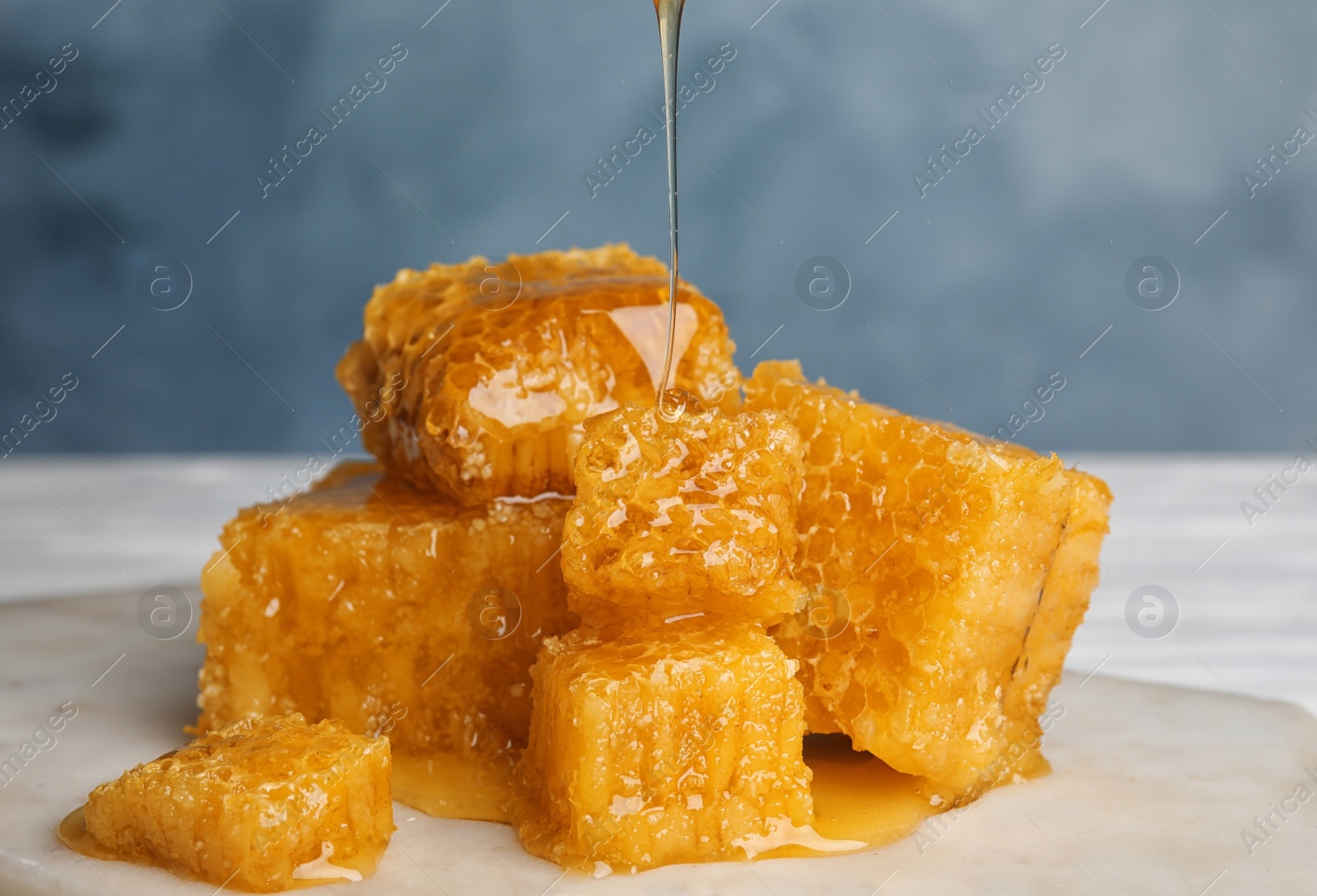 Photo of Fresh delicious dripping honey on white table, closeup