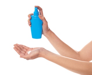 Photo of Woman with bottle of sun protection body cream on white background, closeup