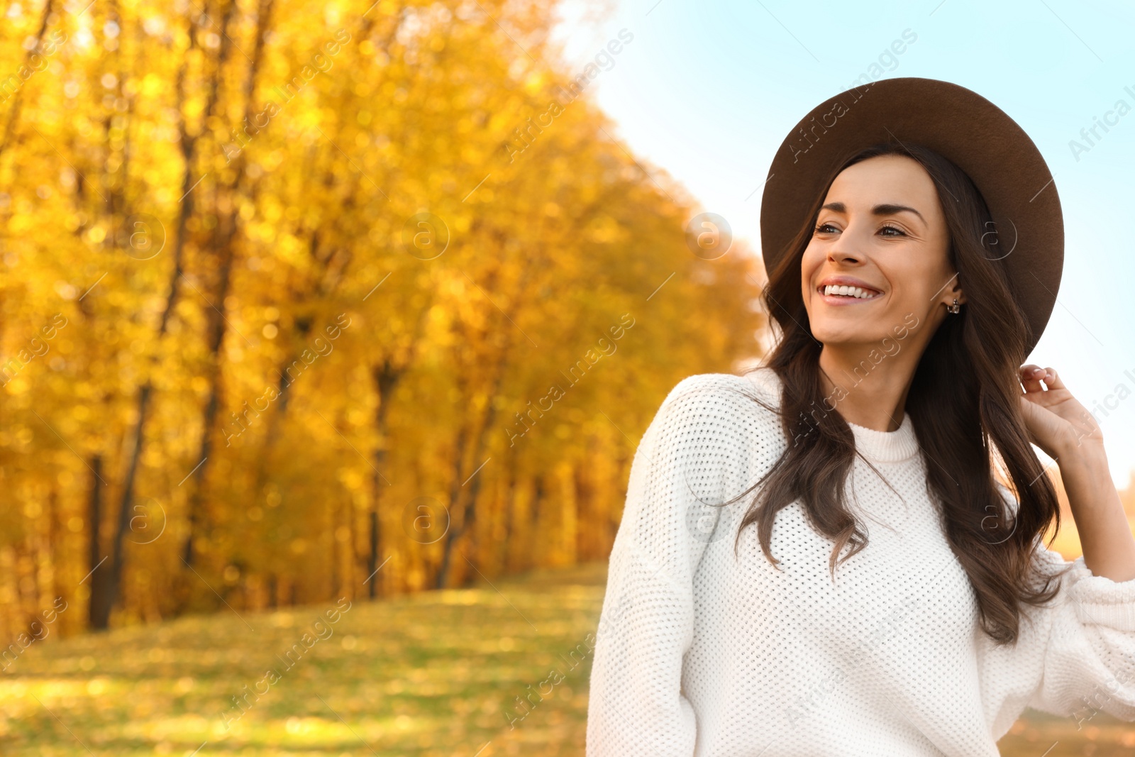 Photo of Beautiful happy woman wearing hat in park. Autumn walk