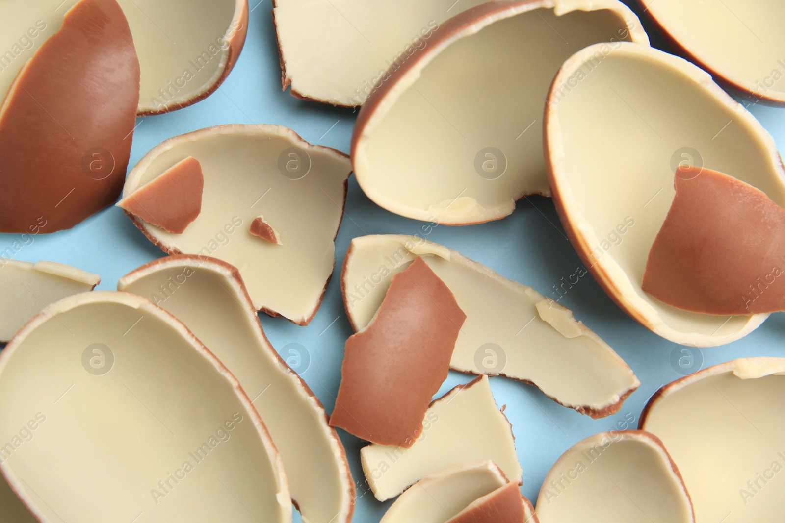 Photo of Sveti Vlas, Bulgaria - July 3, 2023: Broken halves of Kinder Surprise Eggs on light blue background, flat lay