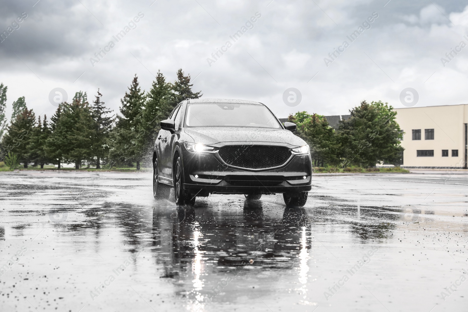 Photo of Modern car driving outdoors on rainy day