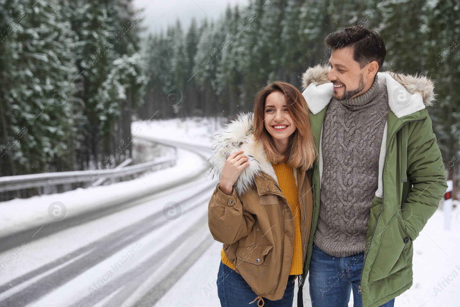 Photo of Couple walking near snowy forest, space for text. Winter vacation