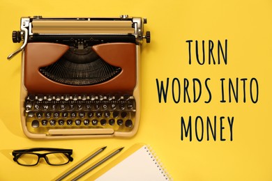 Image of Phrase Turn Words Into Money near typewriter, glasses and stationery on yellow background, flat lay