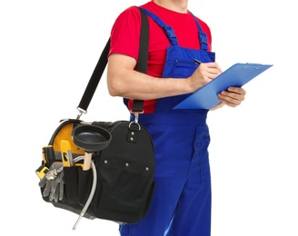 Young plumber with tool bag and clipboard on white background