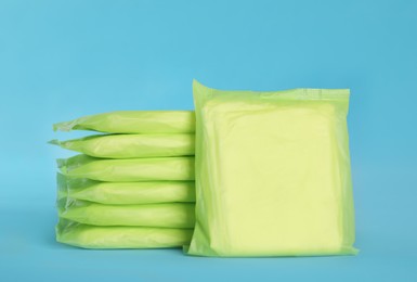 Photo of Stack of menstrual pads on light blue background