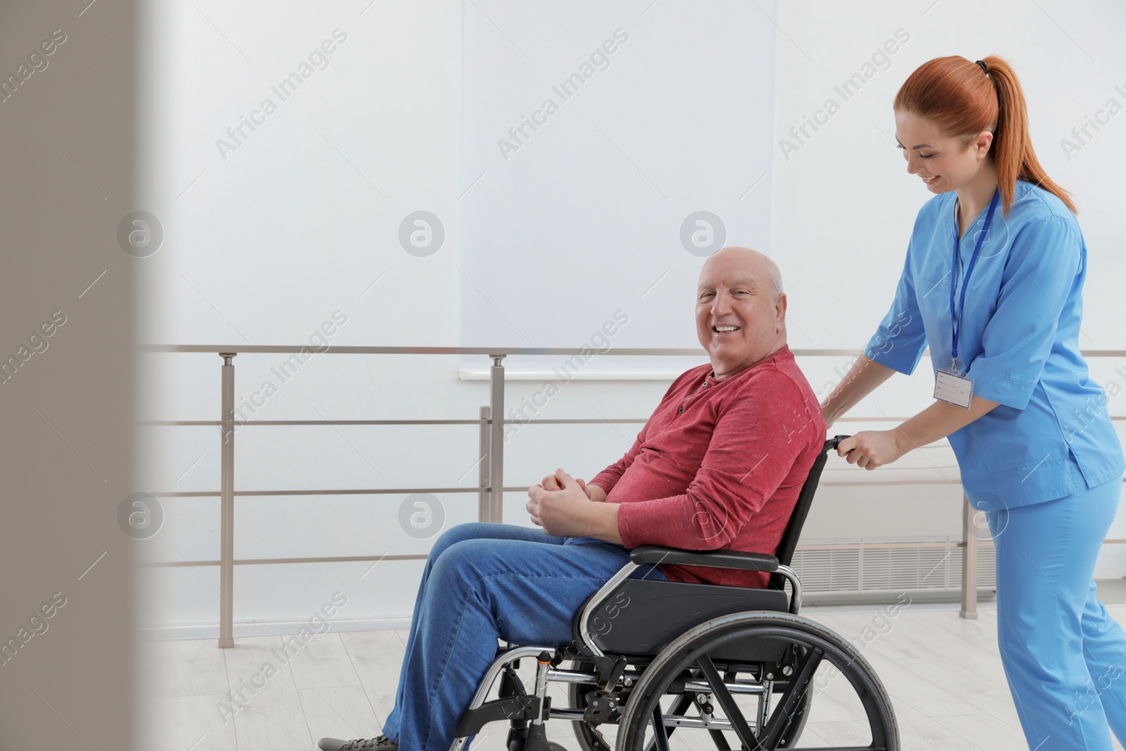 Photo of Nurse assisting senior man in wheelchair at hospital