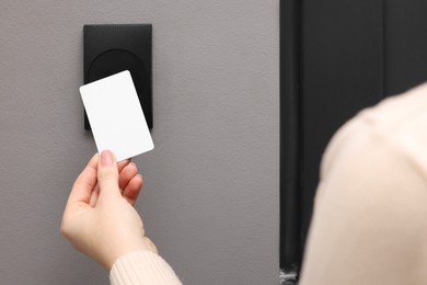 Photo of Woman opening magnetic door lock with key card, closeup. Home security