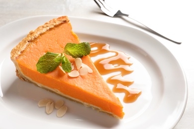 Plate with piece of fresh delicious homemade pumpkin pie on table, closeup