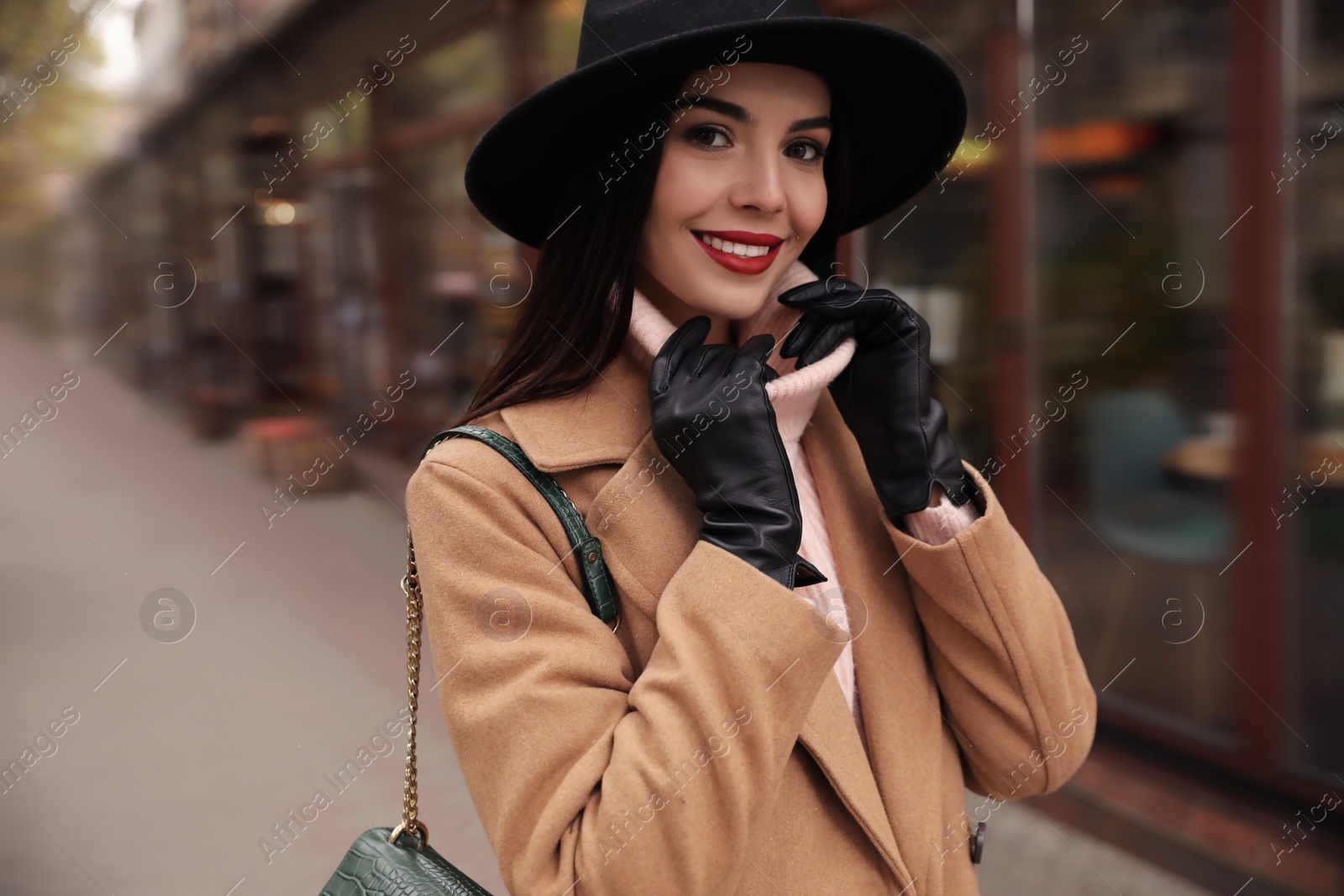 Photo of Young woman wearing stylish clothes on city street. Autumn look