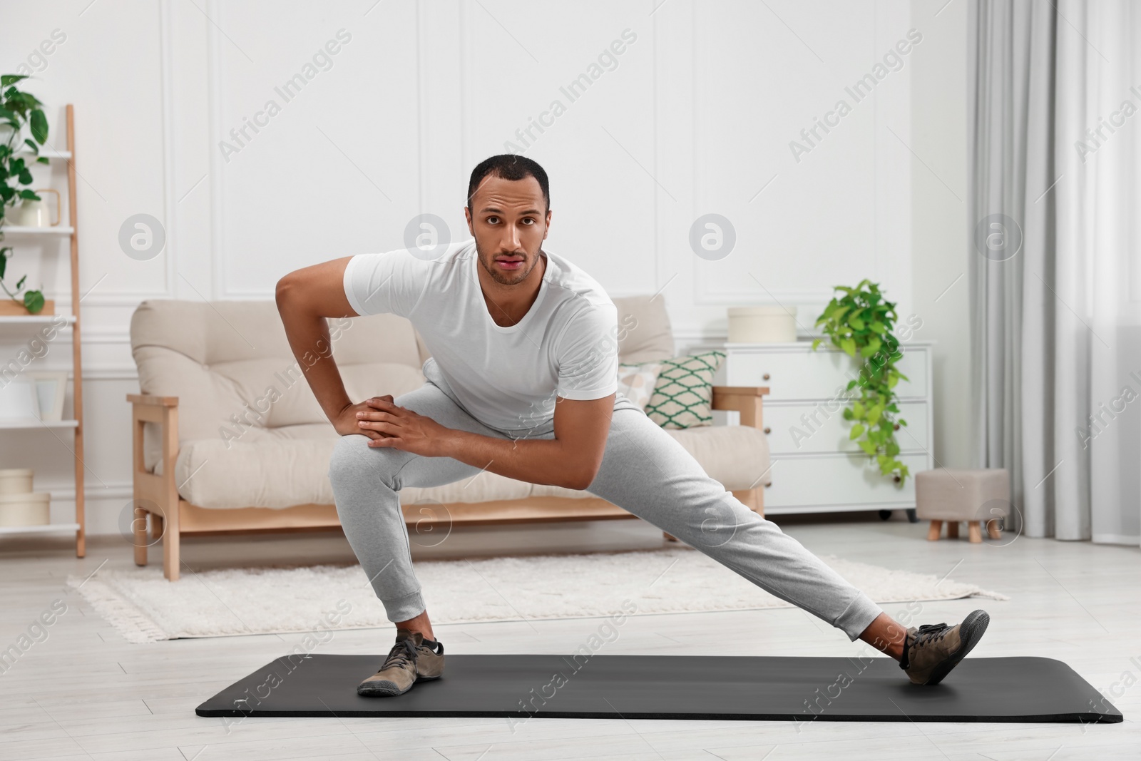 Photo of Man doing morning exercise on fitness mat at home