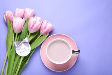 Cup of hot drink, beautiful tulips and card with text Good Morning on light purple background, flat lay