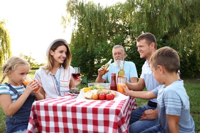 Happy family having barbecue in park on sunny day