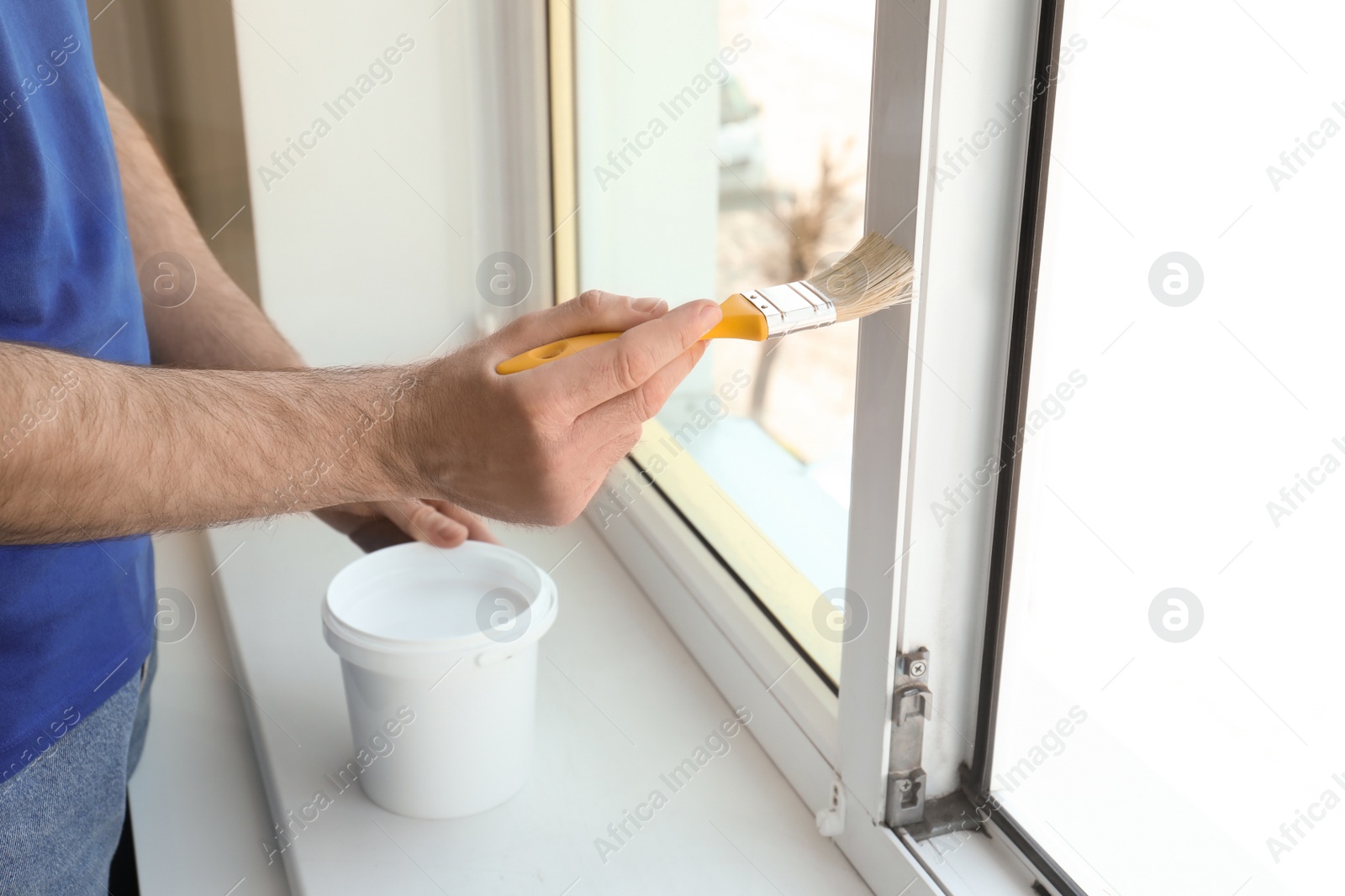 Photo of Man painting window frame at home, closeup