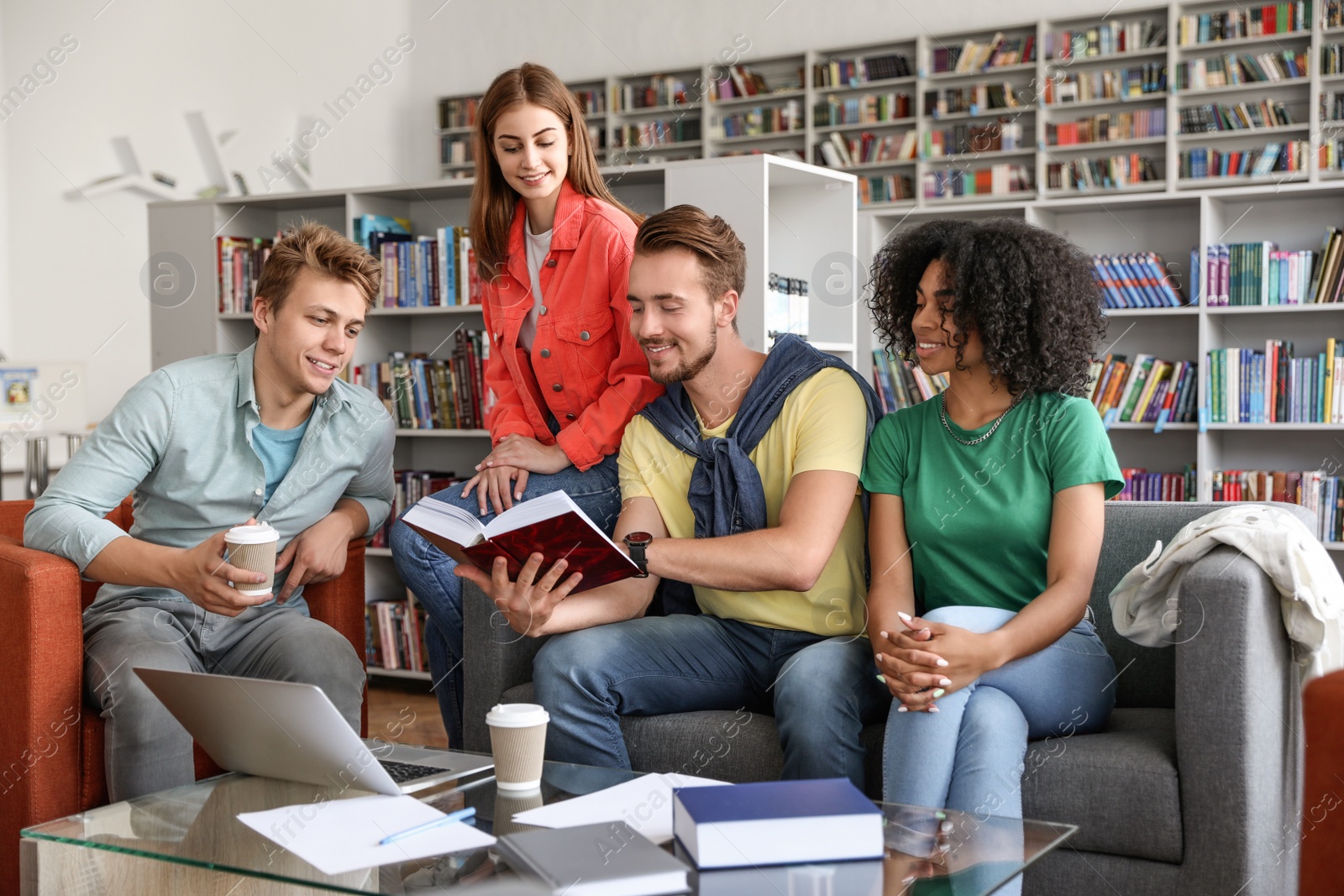 Photo of Group of young people studying at table in library