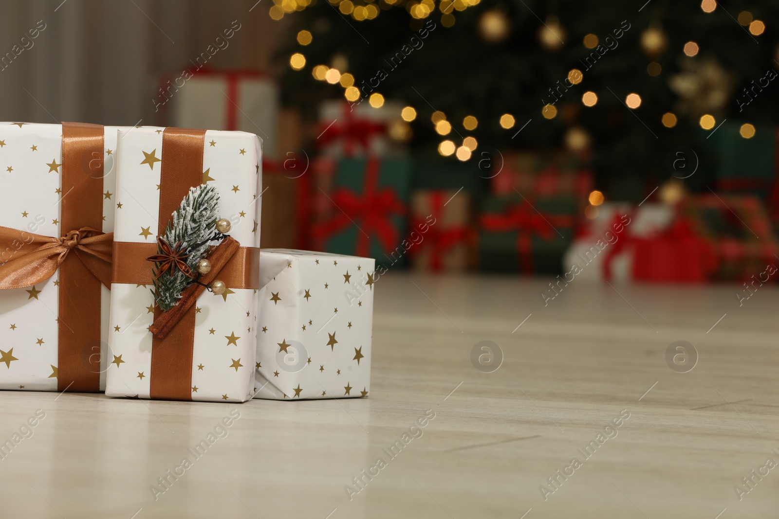 Photo of Gift boxes on floor near Christmas tree in room, space for text