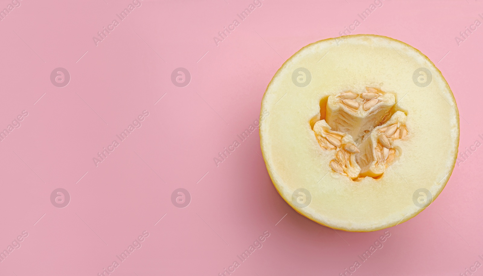 Photo of Half of ripe tasty melon on pink background, top view. Space for text