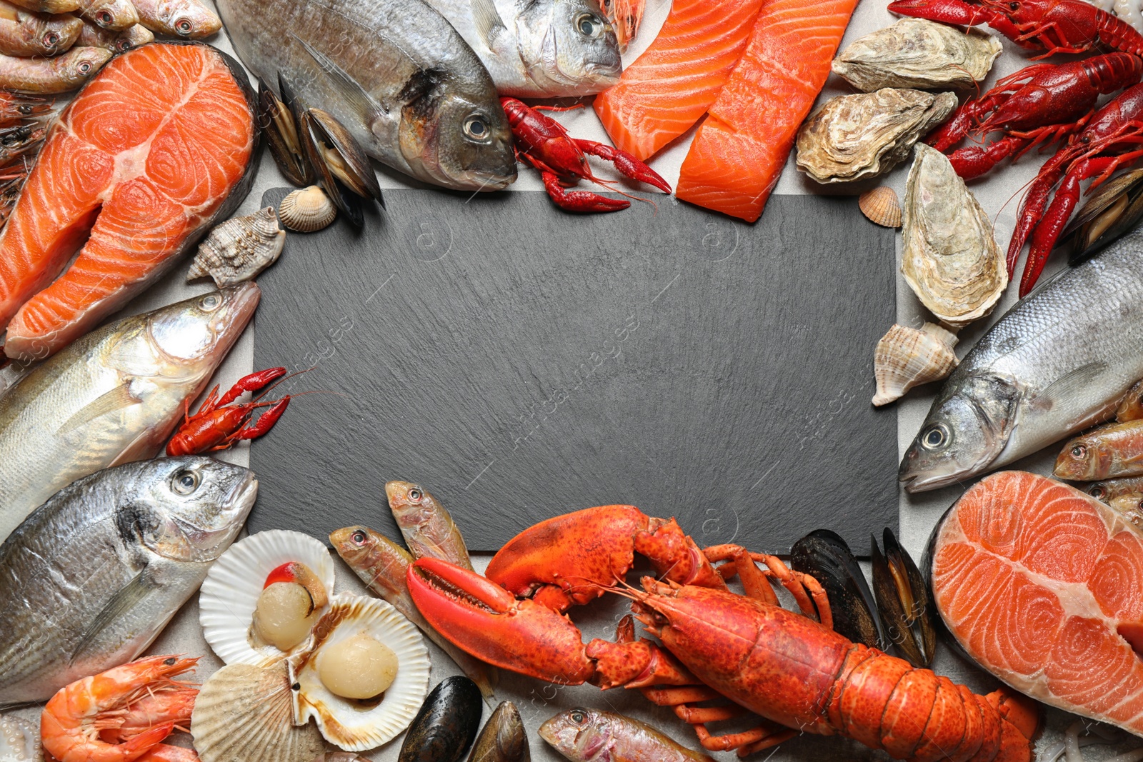 Photo of Fresh fish and different seafood on grey table, flat lay. Space for text