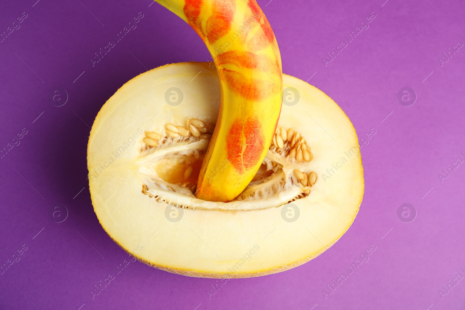 Photo of Flat lay composition with fresh banana and melon on purple background. Sex concept